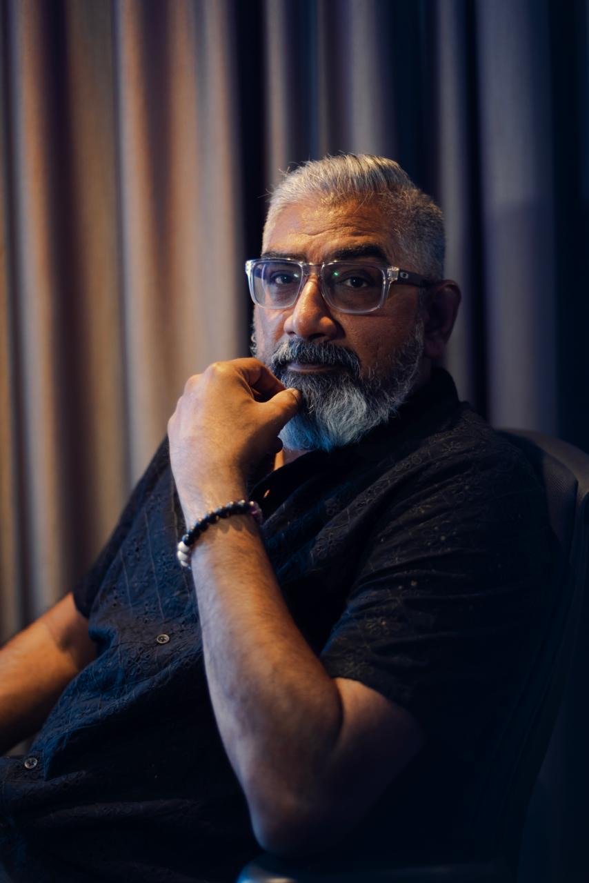 Close portrait of Dinesh in a black shirt with a thoughtful expression