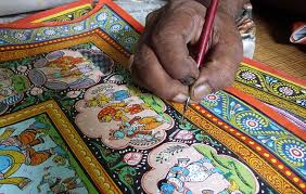 Hands of a Patua artist painting a Pattachitra scroll